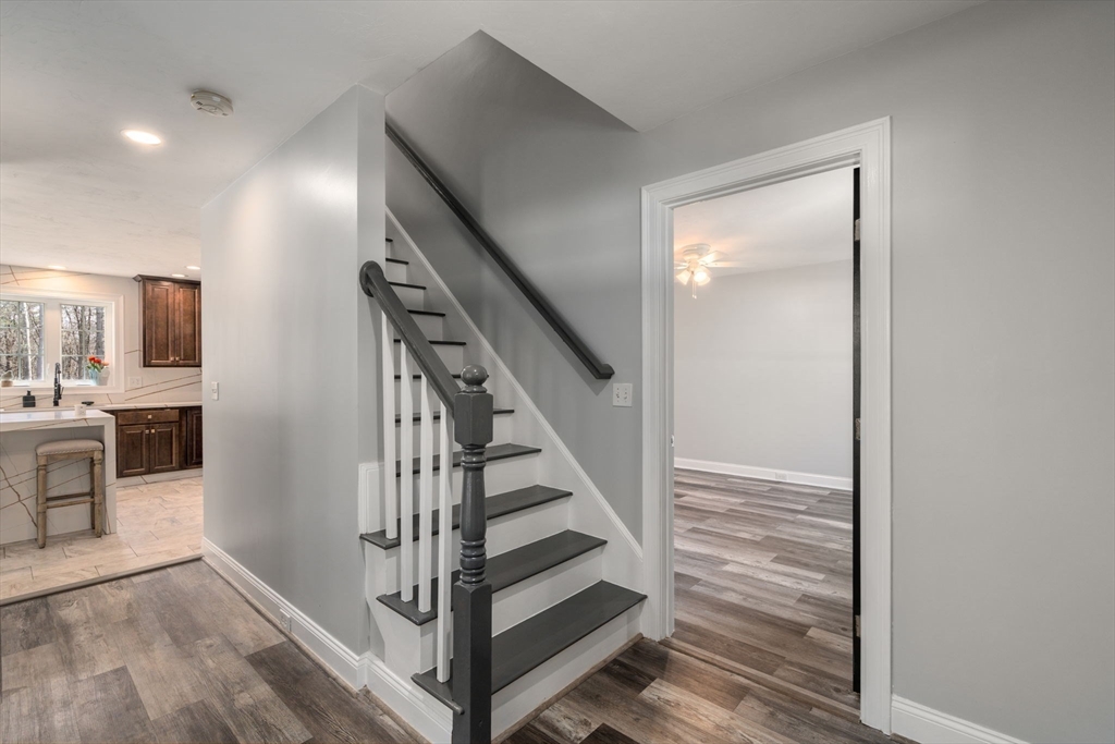 2 Britlees Way Dudley, MA 01571 - Photo 16 of 40 a view of a hallway with kitchen island wooden floor and stainless steel appliances