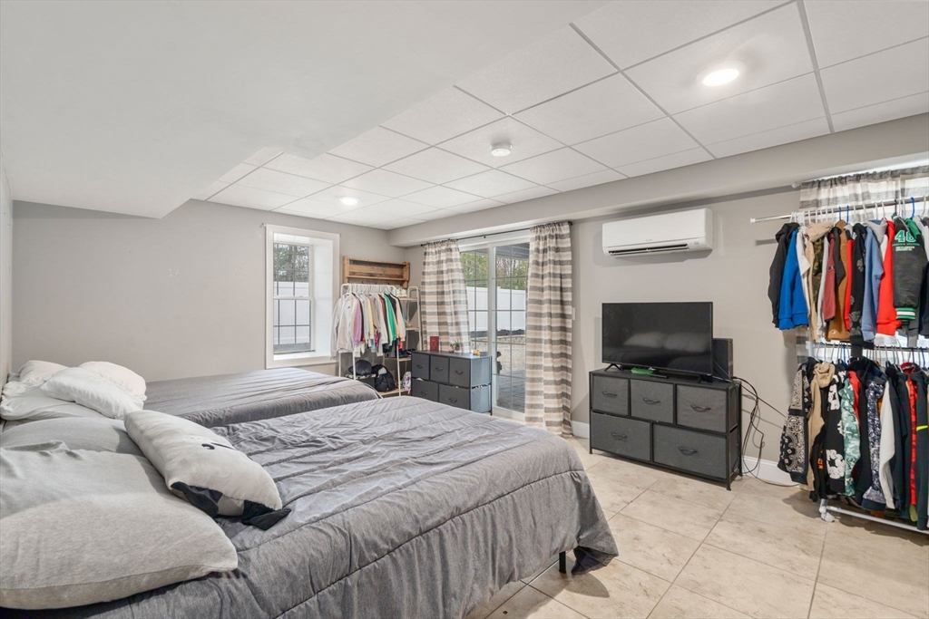 2 Britlees Way Dudley, MA 01571 - Photo 29 of 40 a bedroom with a bed a flat screen tv and a large window