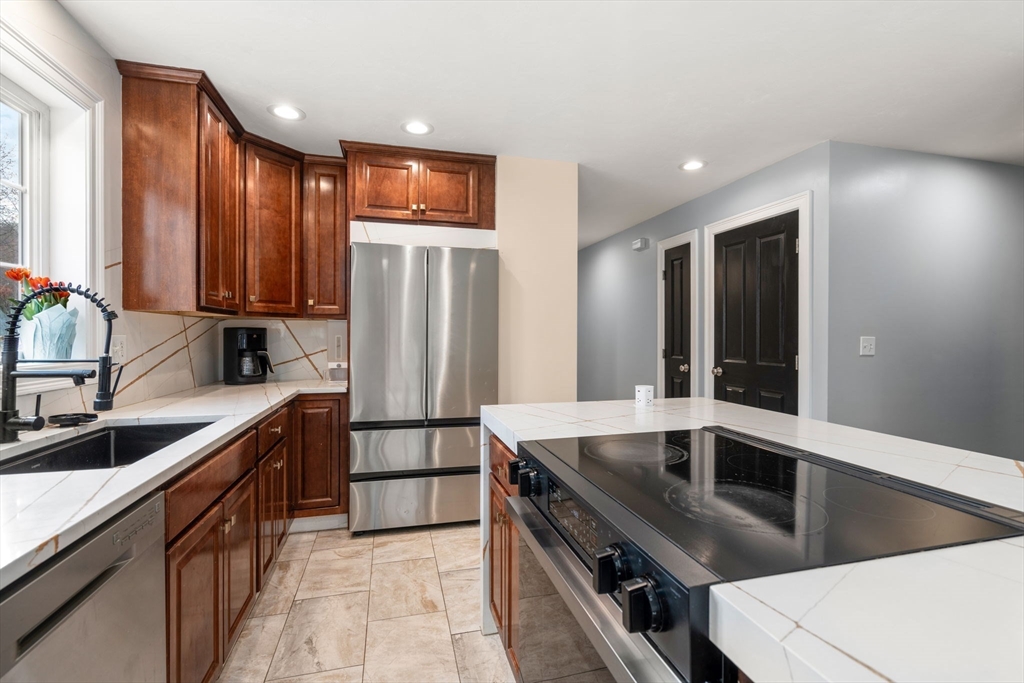 2 Britlees Way Dudley, MA 01571 - Photo 7 of 40 a kitchen with stainless steel appliances granite countertop a sink a stove and a refrigerator