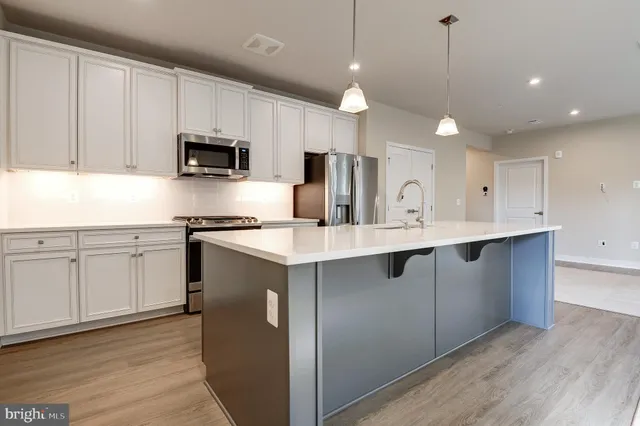 a kitchen with kitchen island white cabinets and stainless steel appliances