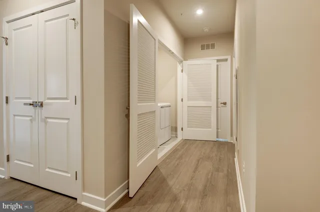 a view of a hallway with wooden floor