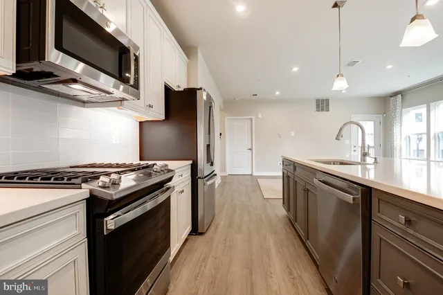 a kitchen with stainless steel appliances granite countertop a stove a sink and a microwave