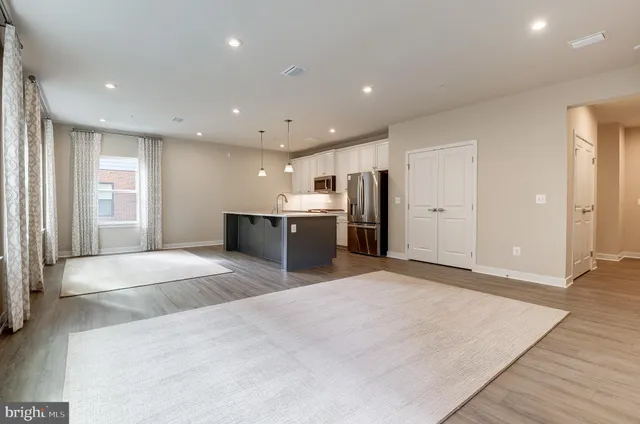 a large space with stainless steel appliances kitchen island a sink granite counter tops and a large window