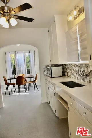 a spacious en suite bathroom with a granite countertop sink and a mirror