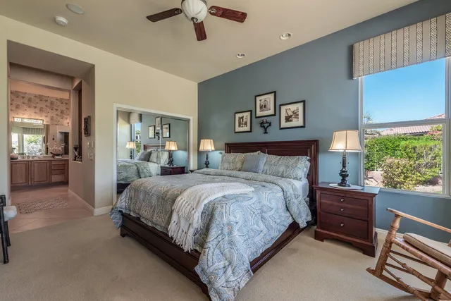 a spacious bedroom with a bed and a chandelier