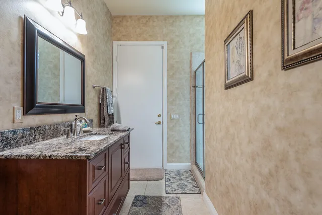 a bathroom with a granite countertop sink and a mirror