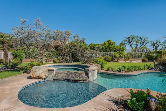 a view of a house with a backyard and swimming pool