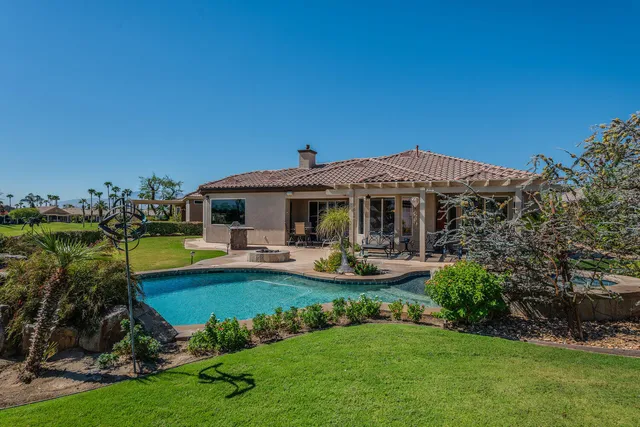 a view of a house with swimming pool and sitting area