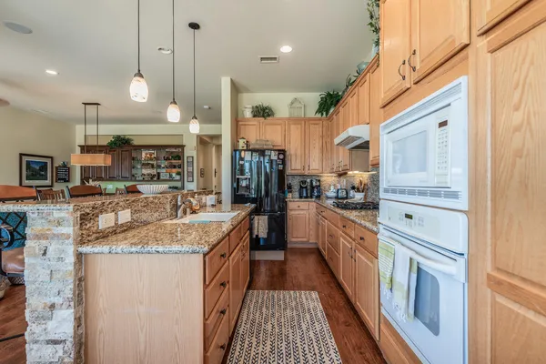 a kitchen with stainless steel appliances granite countertop a sink and a refrigerator
