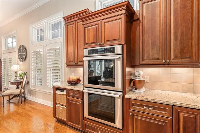 a kitchen with stainless steel appliances granite countertop a refrigerator a stove and a sink with cabinets