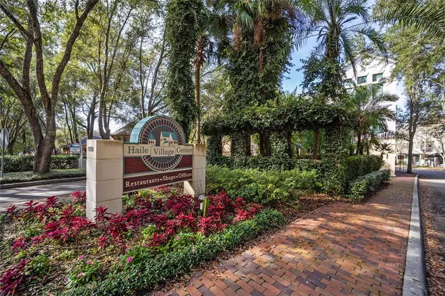 a backyard of a house with large trees and plants