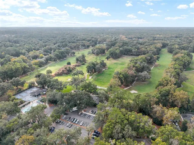 a view of a brick house with many windows next to a yard