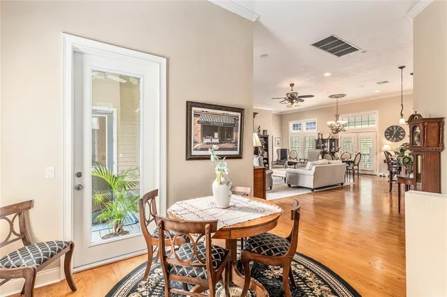 a living room with furniture kitchen view and a wooden floor