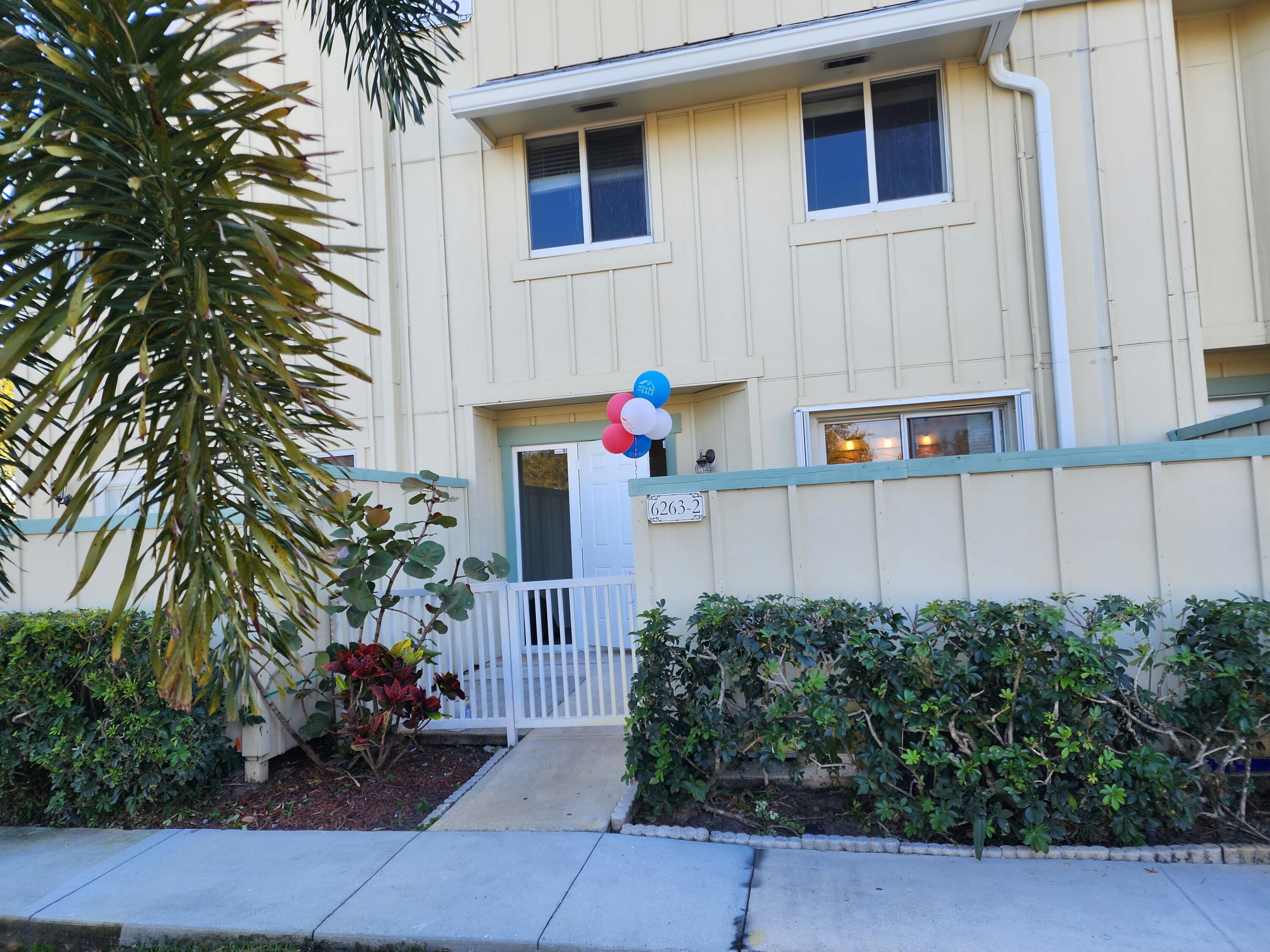 6263 Riverwalk Lane, Unit 2 Jupiter, FL 33458 - Photo 11 of 44 a backyard of a house with potted plants and seating space