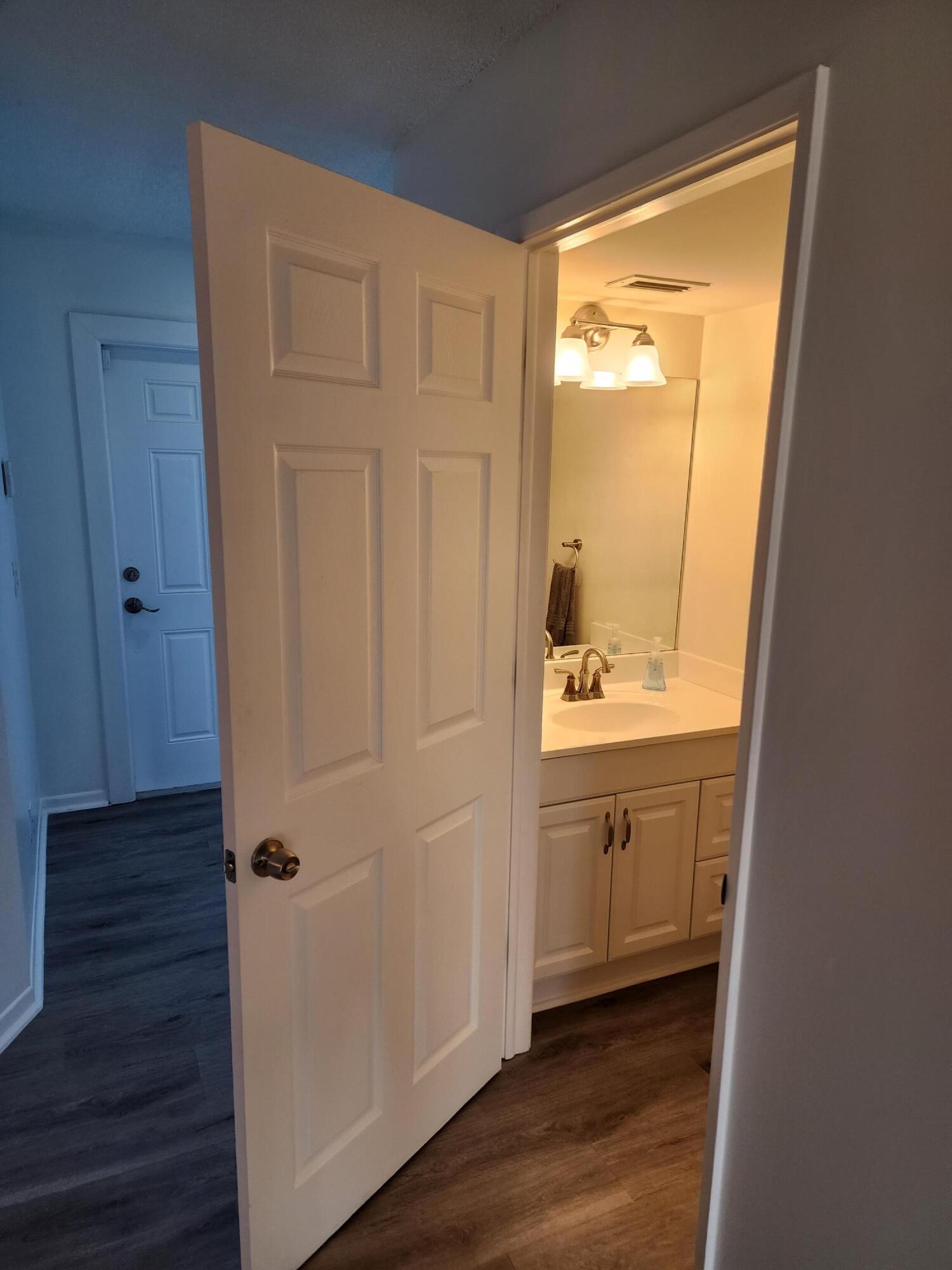 6263 Riverwalk Lane, Unit 2 Jupiter, FL 33458 - Photo 16 of 44 a bathroom with a sink a mirror and a shower