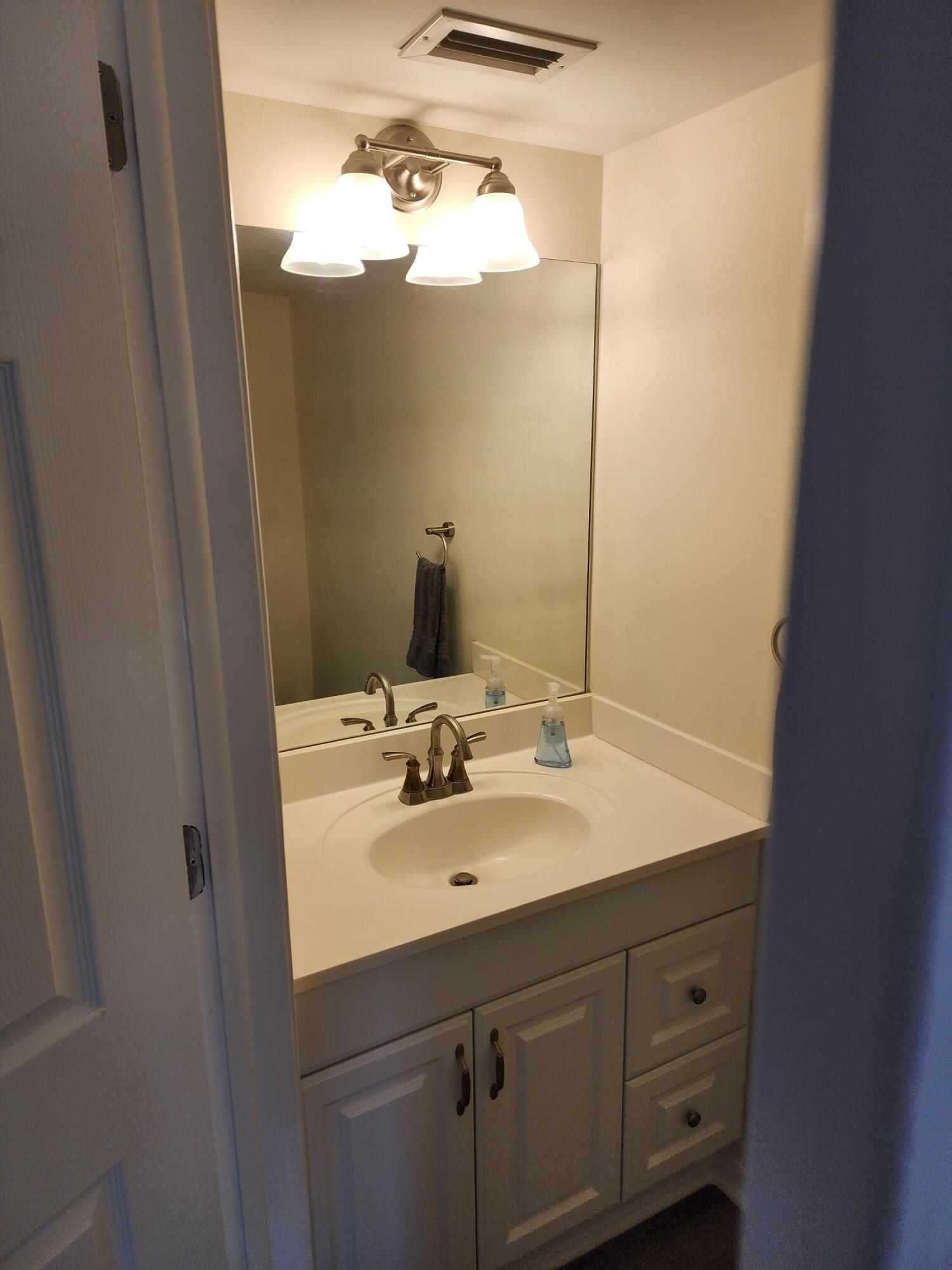 6263 Riverwalk Lane, Unit 2 Jupiter, FL 33458 - Photo 18 of 44 a bathroom with a sink and a mirror