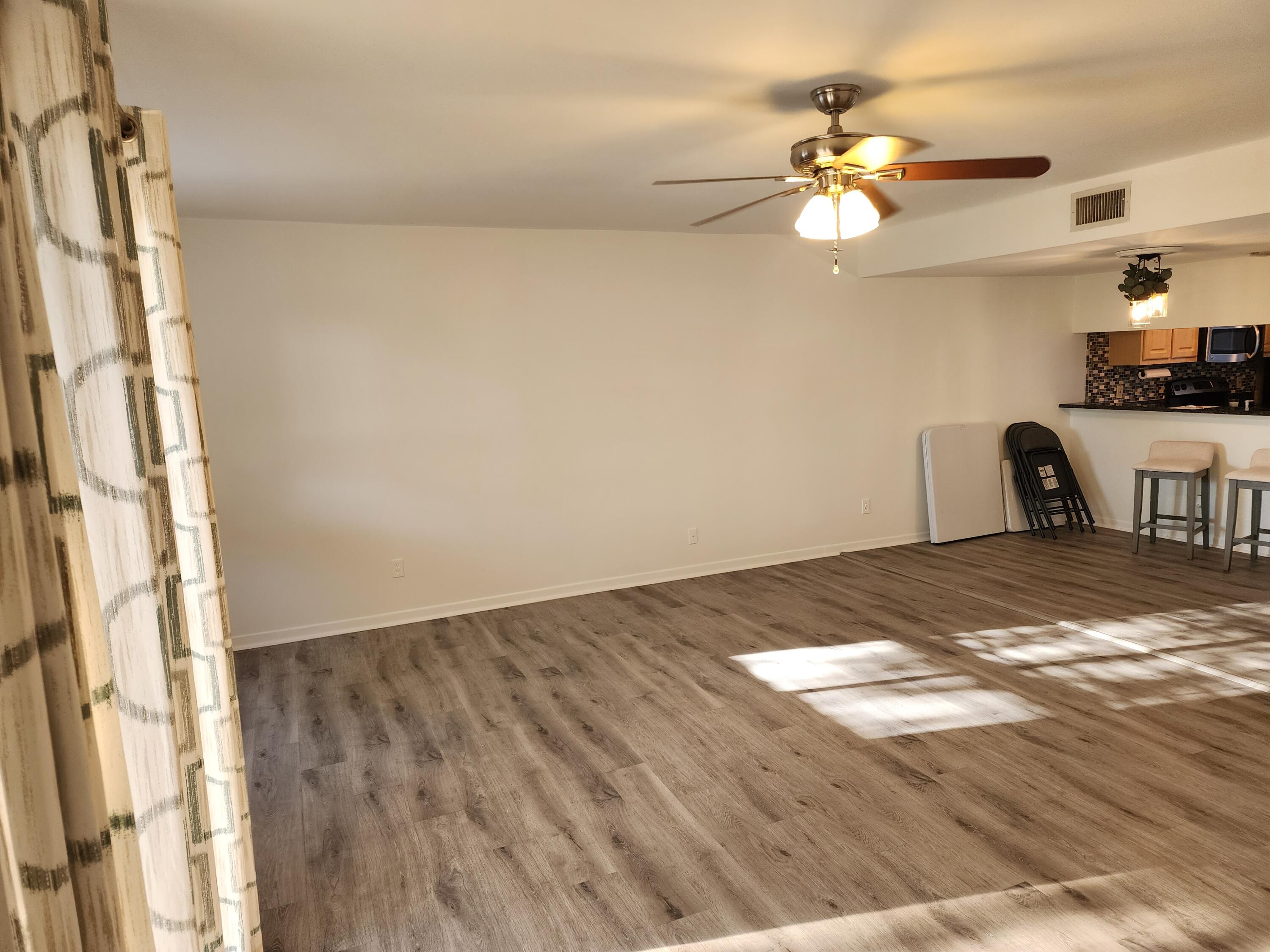 6263 Riverwalk Lane, Unit 2 Jupiter, FL 33458 - Photo 20 of 44 a view of a livingroom with wooden floor and a ceiling fan