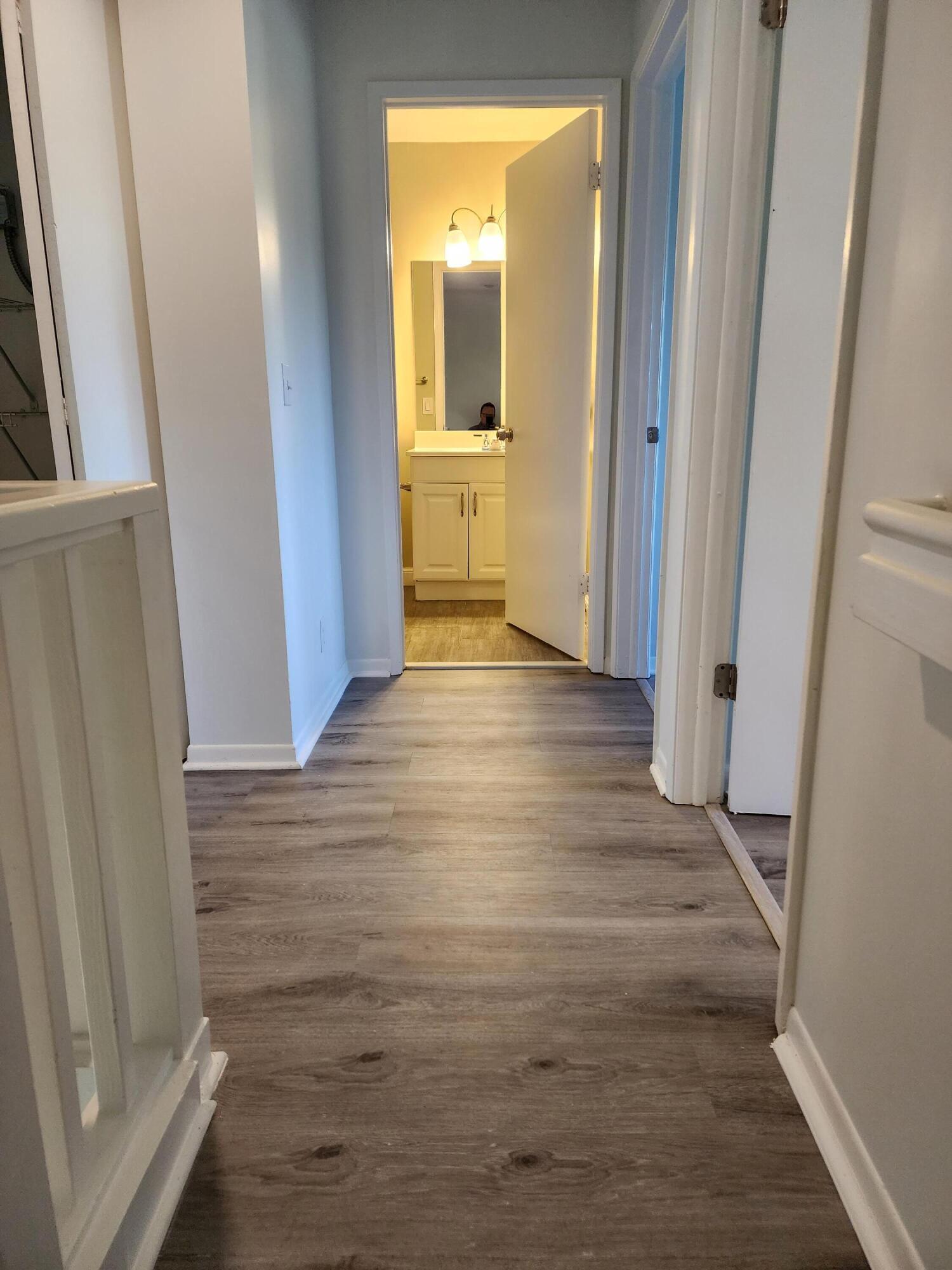 6263 Riverwalk Lane, Unit 2 Jupiter, FL 33458 - Photo 26 of 44 a view of a hallway with wooden floor and a bathroom