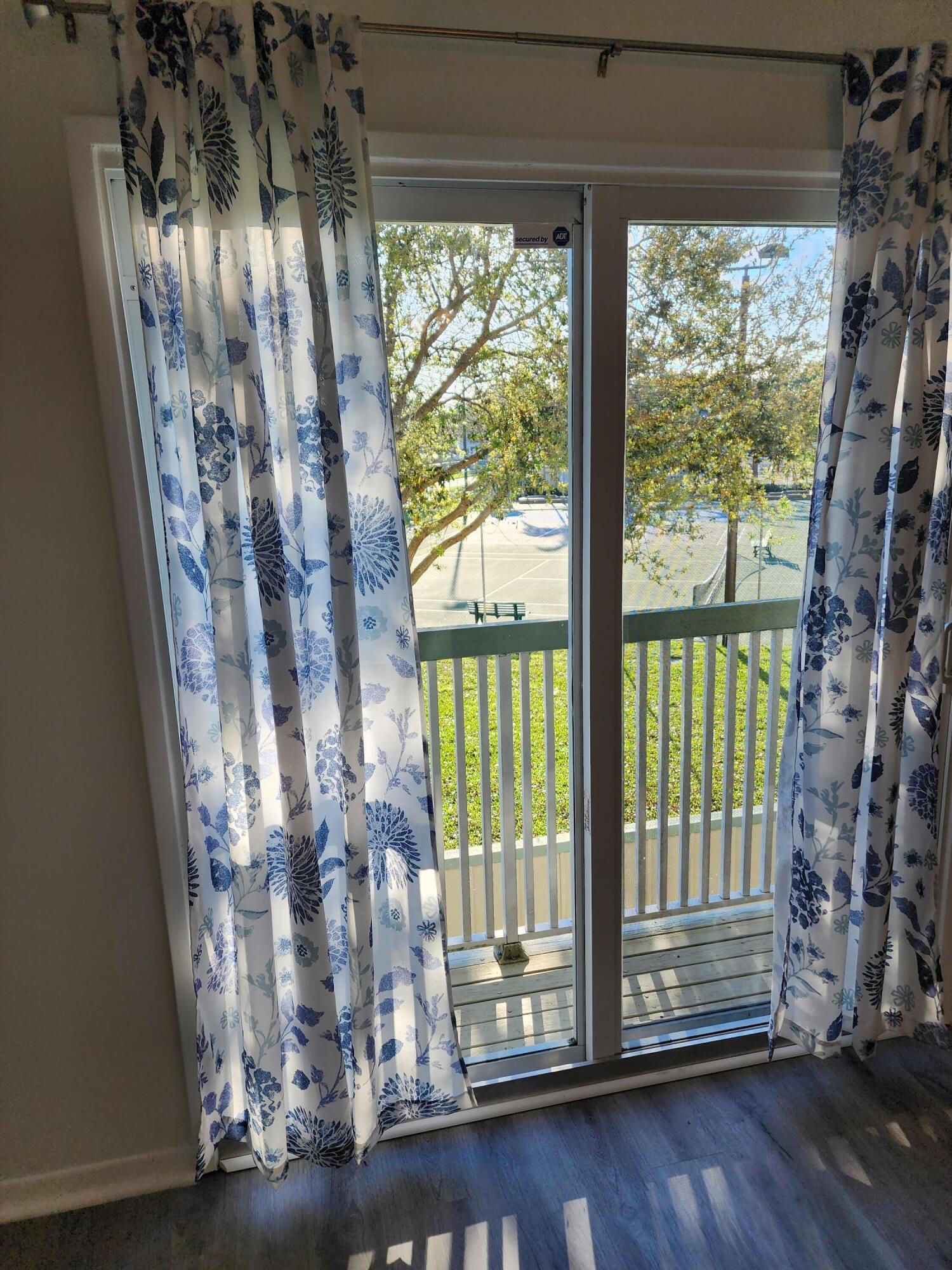 6263 Riverwalk Lane, Unit 2 Jupiter, FL 33458 - Photo 29 of 44 a view of empty room with wooden floor and floor to ceiling window