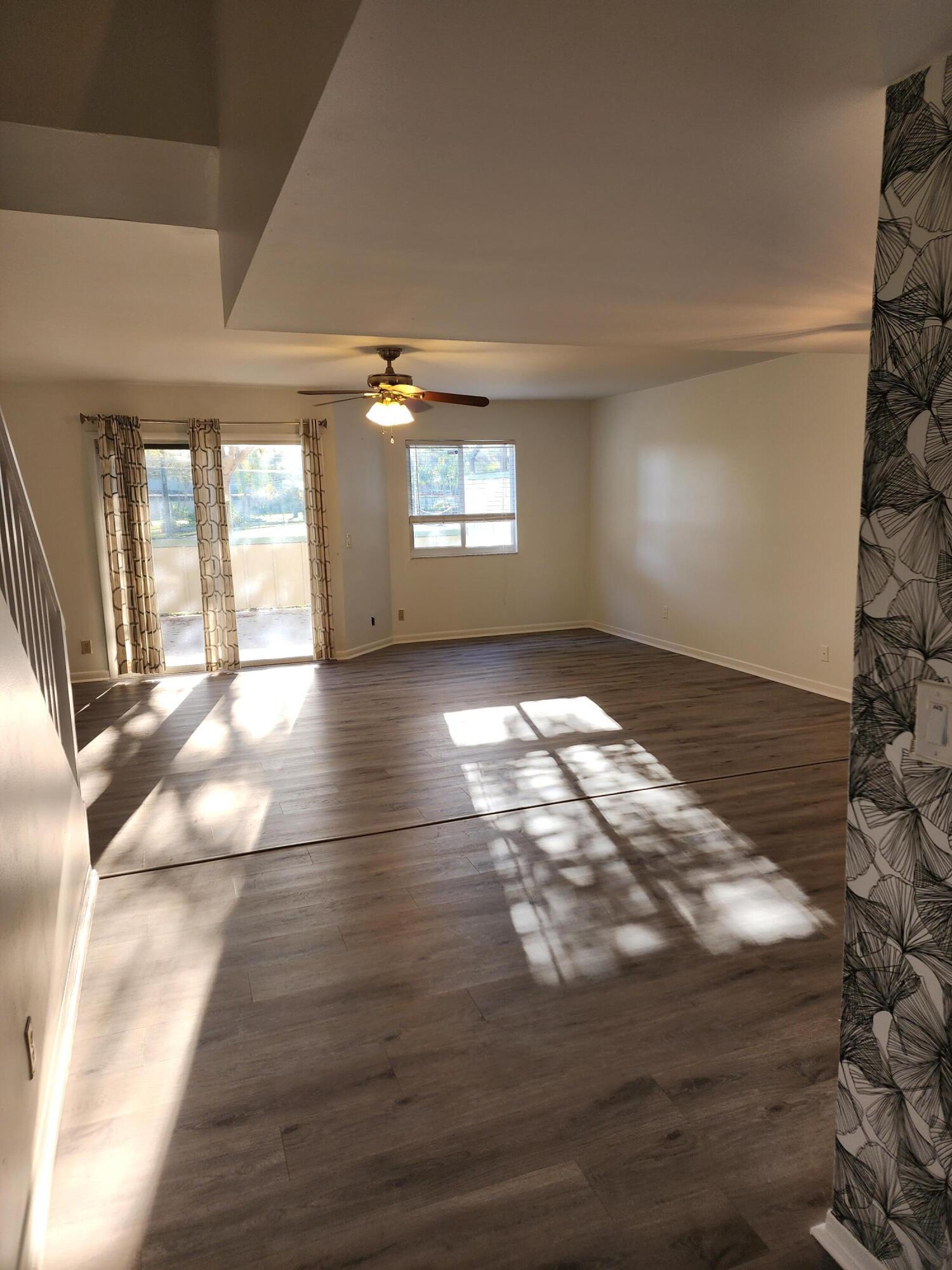 6263 Riverwalk Lane, Unit 2 Jupiter, FL 33458 - Photo 3 of 44 a view of empty room with wooden floor and fan