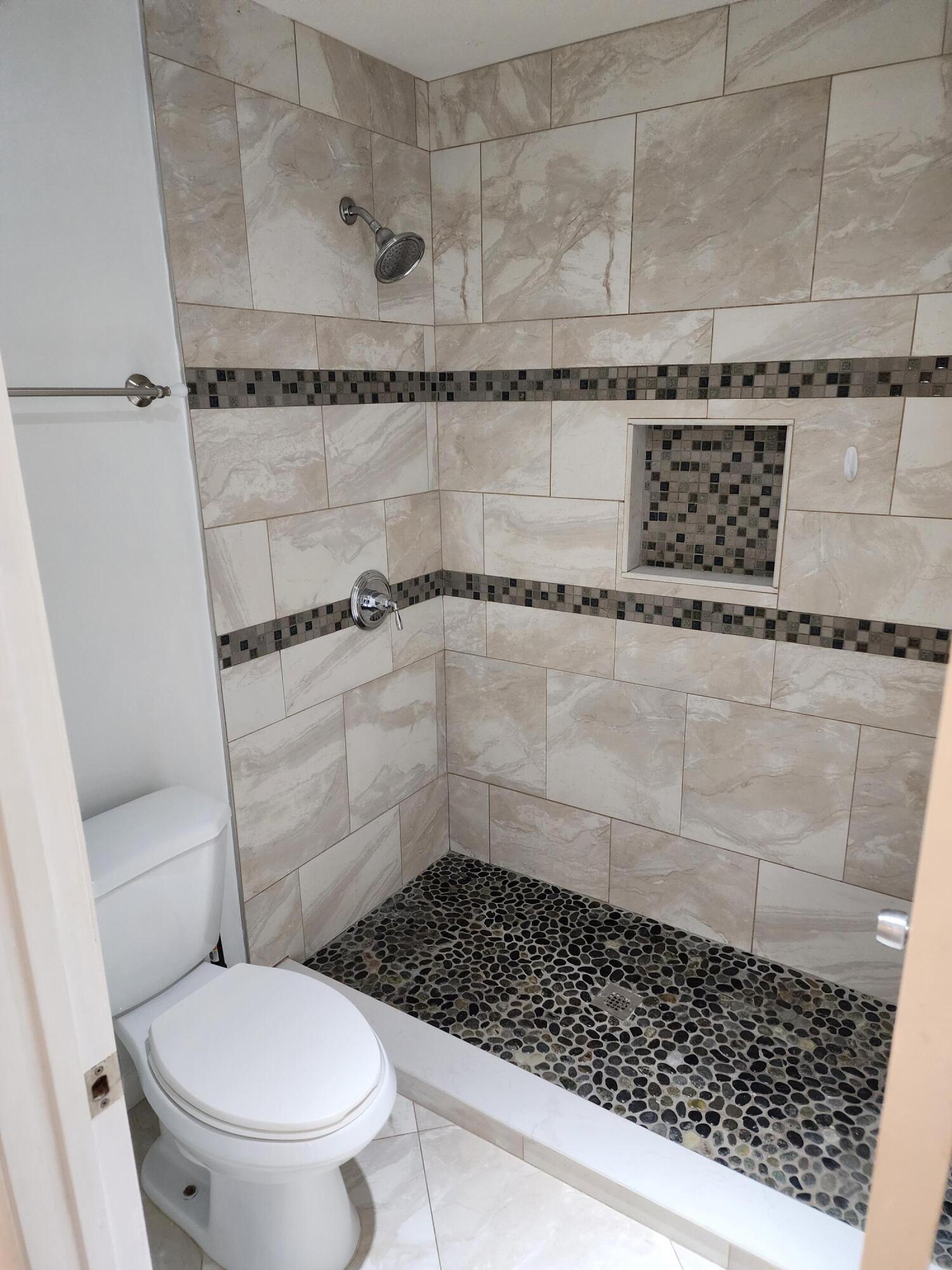6263 Riverwalk Lane, Unit 2 Jupiter, FL 33458 - Photo 32 of 44 a bathroom with a toilet and a shower