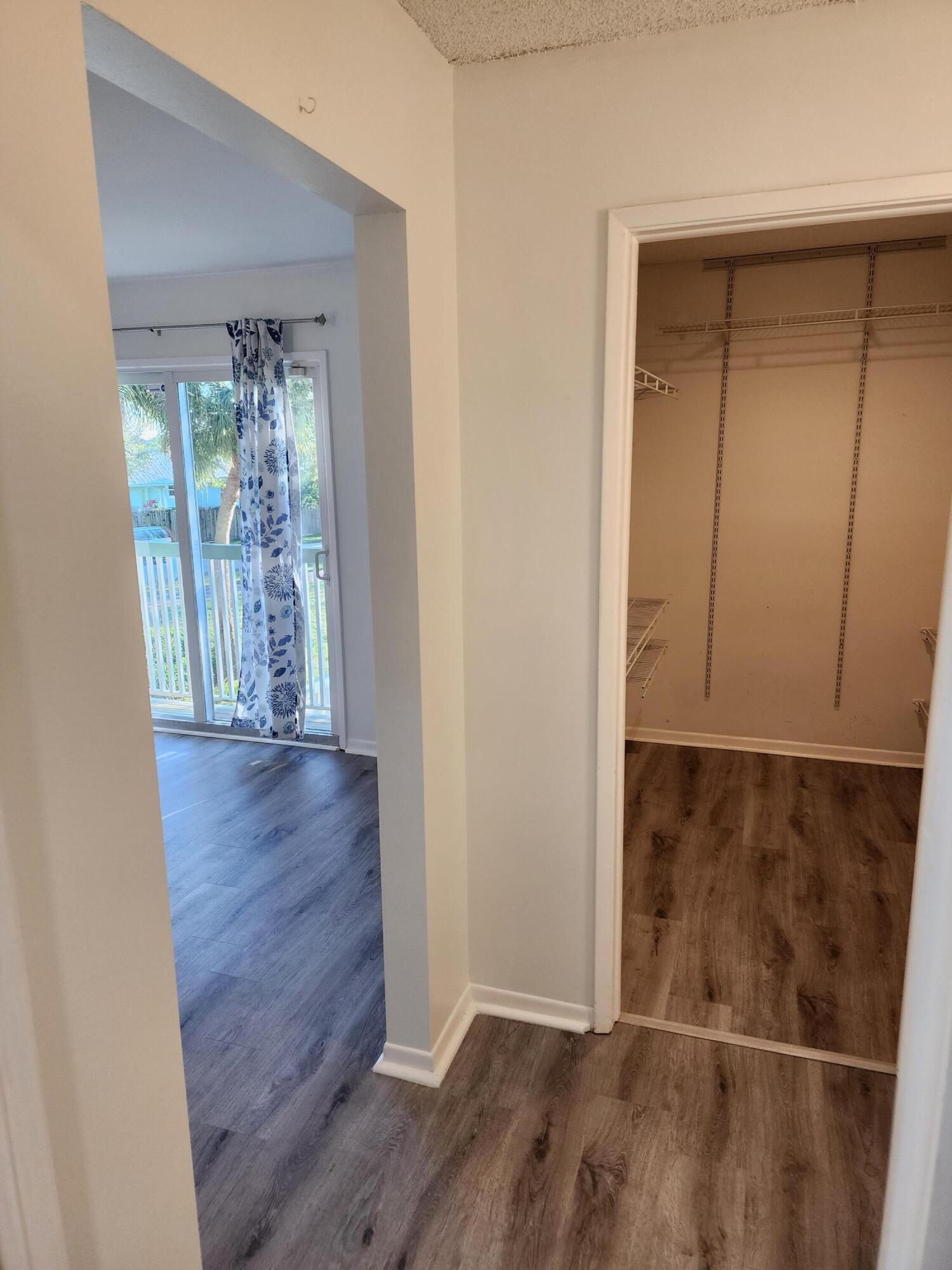 6263 Riverwalk Lane, Unit 2 Jupiter, FL 33458 - Photo 34 of 44 a view of an empty room with wooden floor and a window