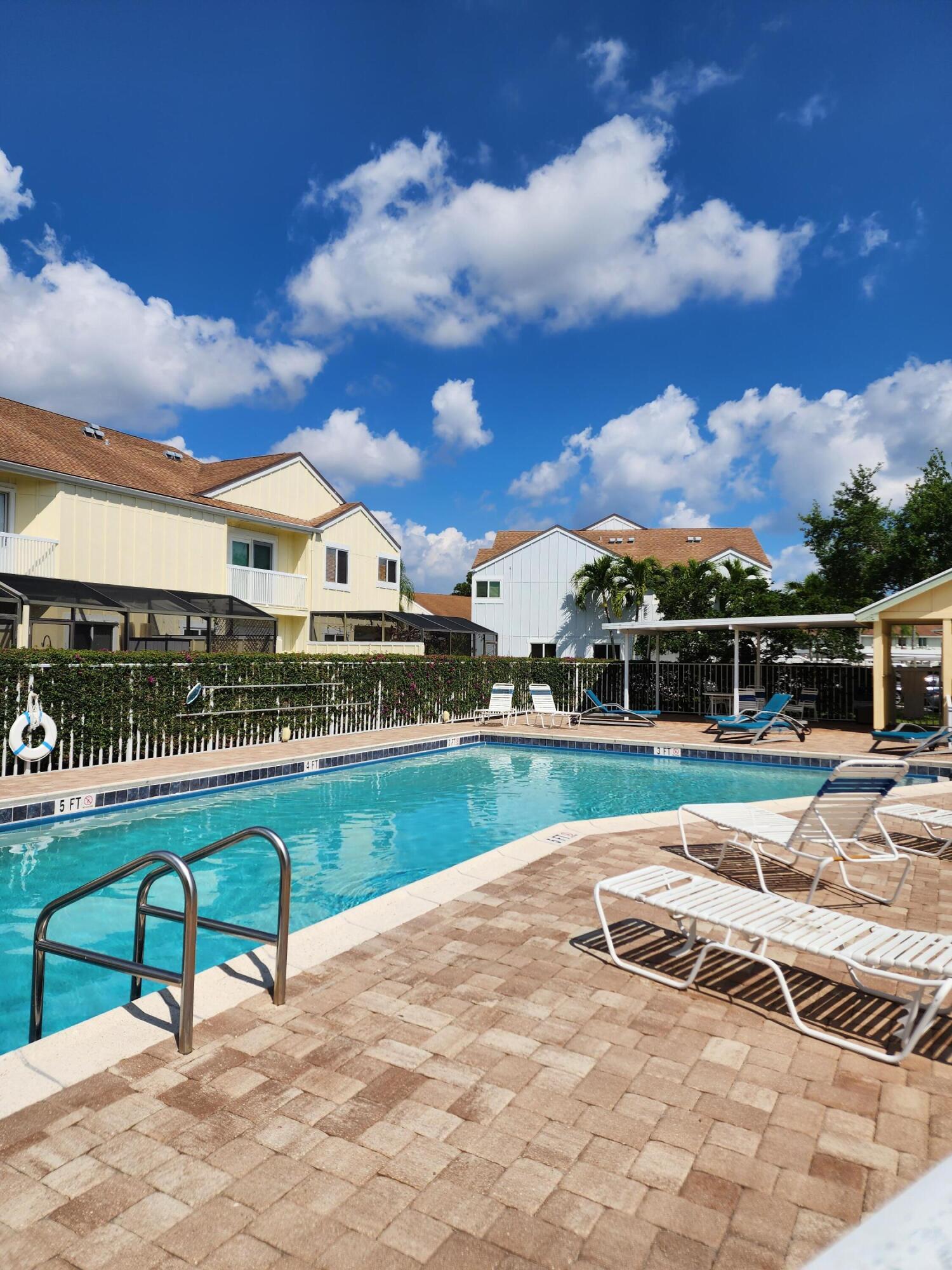 6263 Riverwalk Lane, Unit 2 Jupiter, FL 33458 - Photo 42 of 44 a view of a swimming pool with a lounge chairs