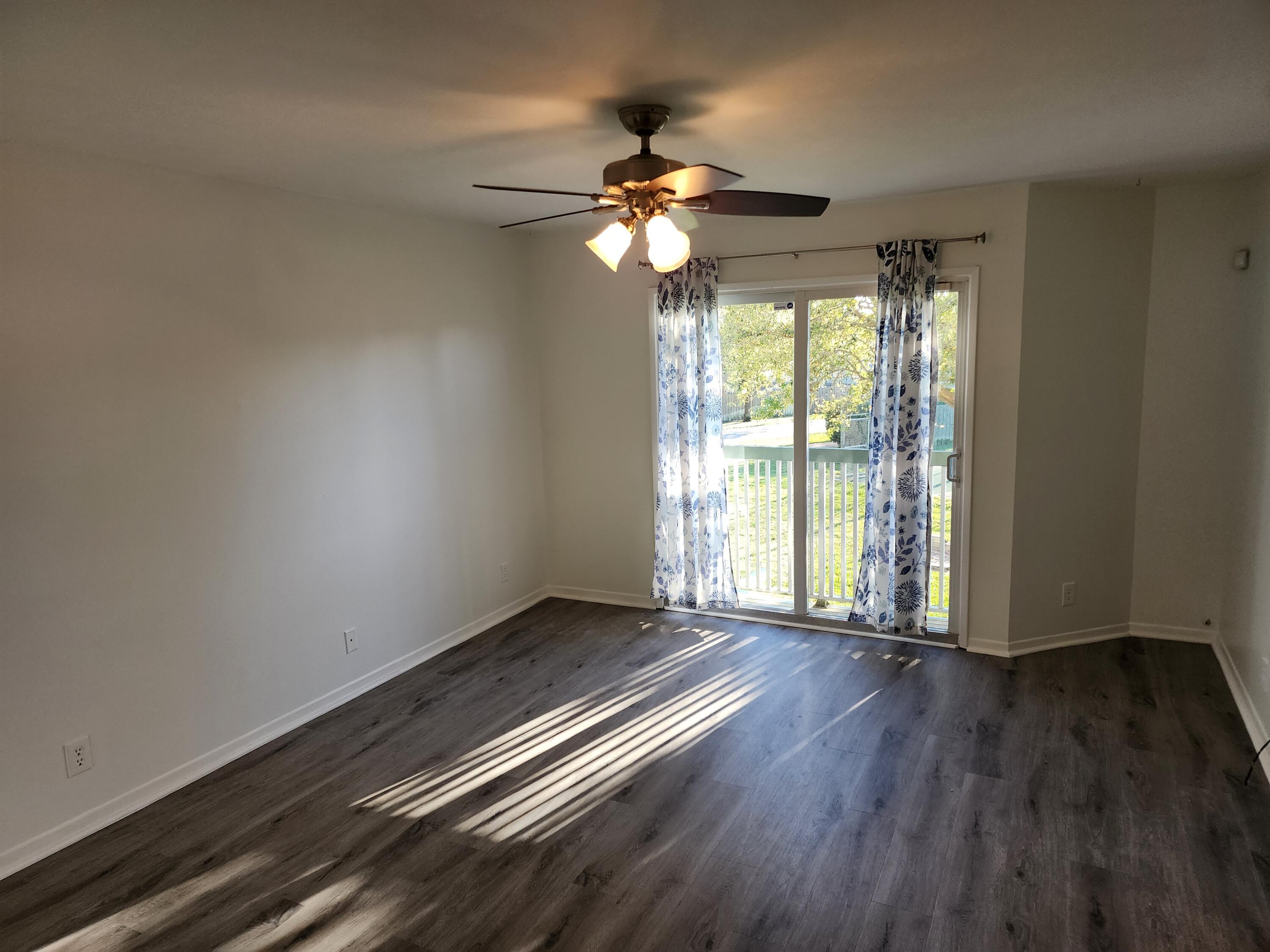 6263 Riverwalk Lane, Unit 2 Jupiter, FL 33458 - Photo 7 of 44 a view of an empty room with wooden floor and a window