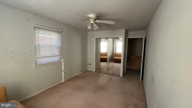 a view of a livingroom with a ceiling fan and window
