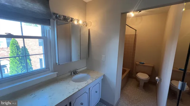 a bathroom with a granite countertop sink toilet and shower