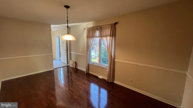 a view of a room with wooden floor and white walls
