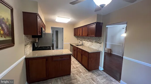 a kitchen with kitchen island wooden cabinets a sink stove and refrigerator