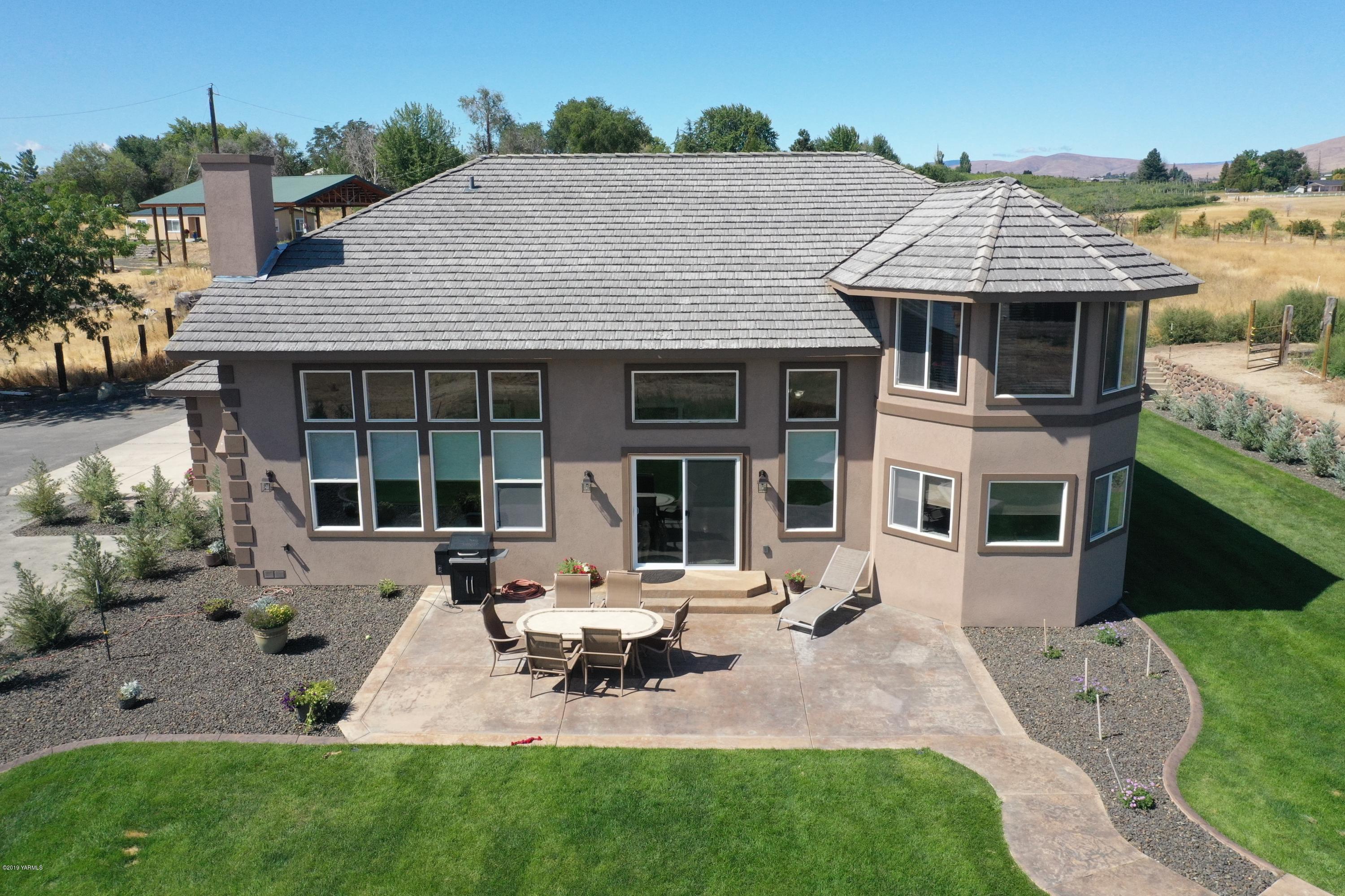 9709 Grunewald Road Yakima, WA 98908 - Photo 13 of 42 a front view of a house with sitting area and garden