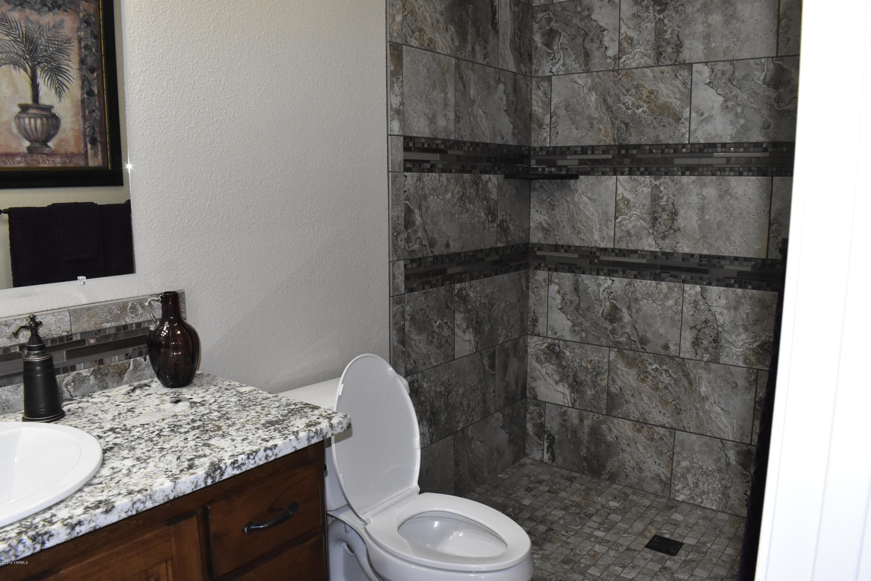 9709 Grunewald Road Yakima, WA 98908 - Photo 18 of 42 a bathroom with a granite countertop sink toilet and shower