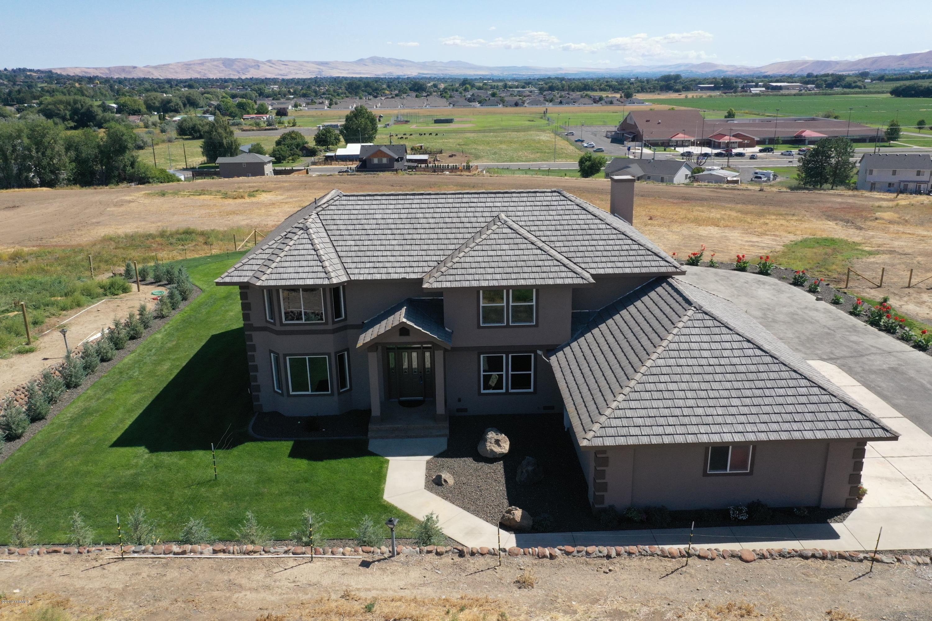 9709 Grunewald Road Yakima, WA 98908 - Photo 5 of 42 a front view of a house with a garden and lake view