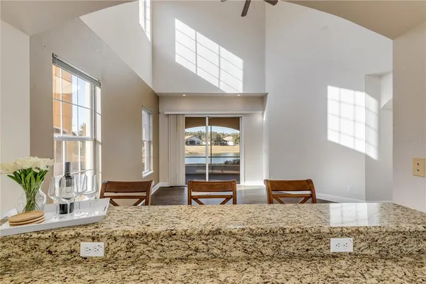 a kitchen with stainless steel appliances granite countertop a sink a refrigerator and white cabinets