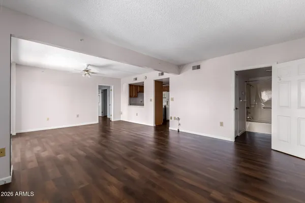a view of a big room with wooden floor and windows