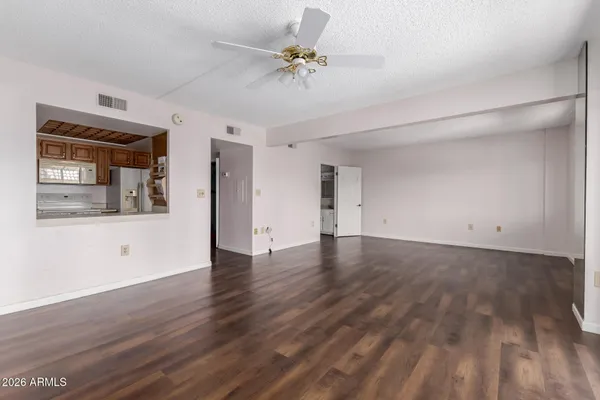 a view of an empty room with a window and wooden floor