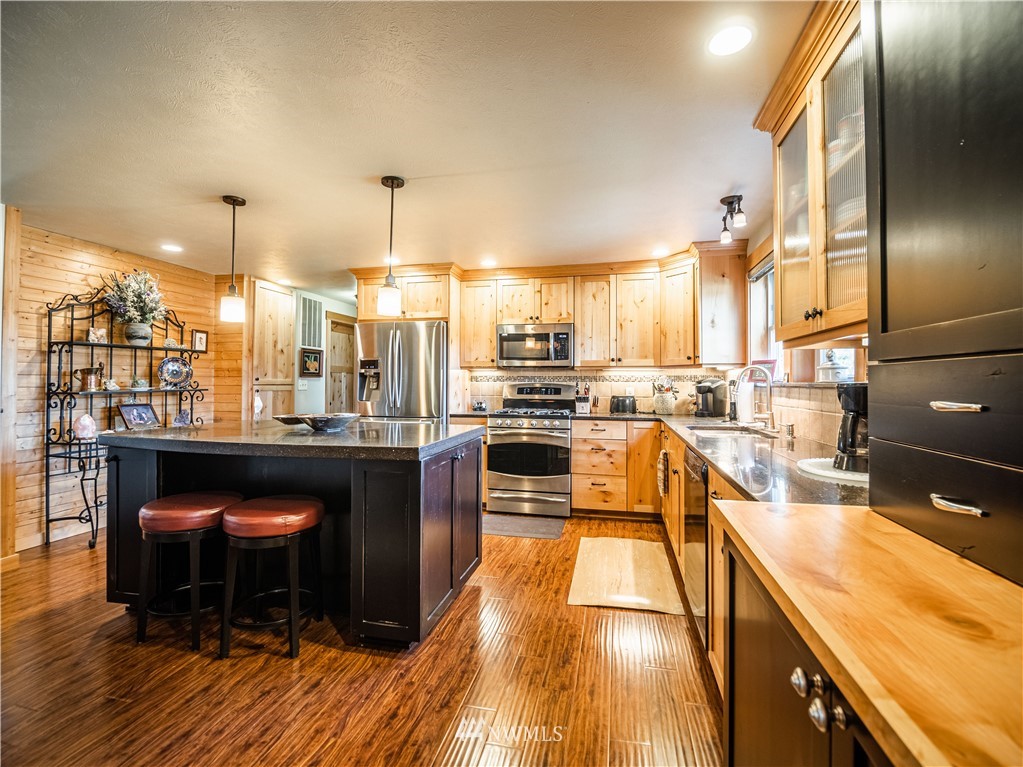 39 Cape Labelle Road Tonasket, WA 98855 - Photo 3 of 39 a kitchen with stainless steel appliances granite countertop a stove a sink and a refrigerator