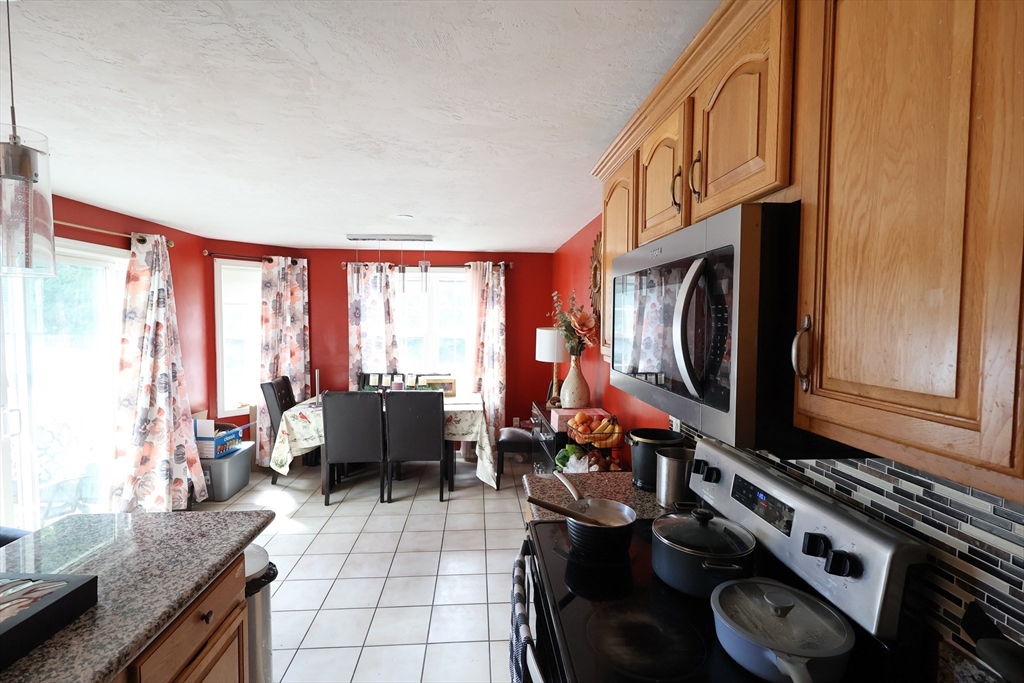 74 Sophia Drive Worcester, MA 01607 - Photo 5 of 15 a living room with furniture a flat screen tv and a floor to ceiling window
