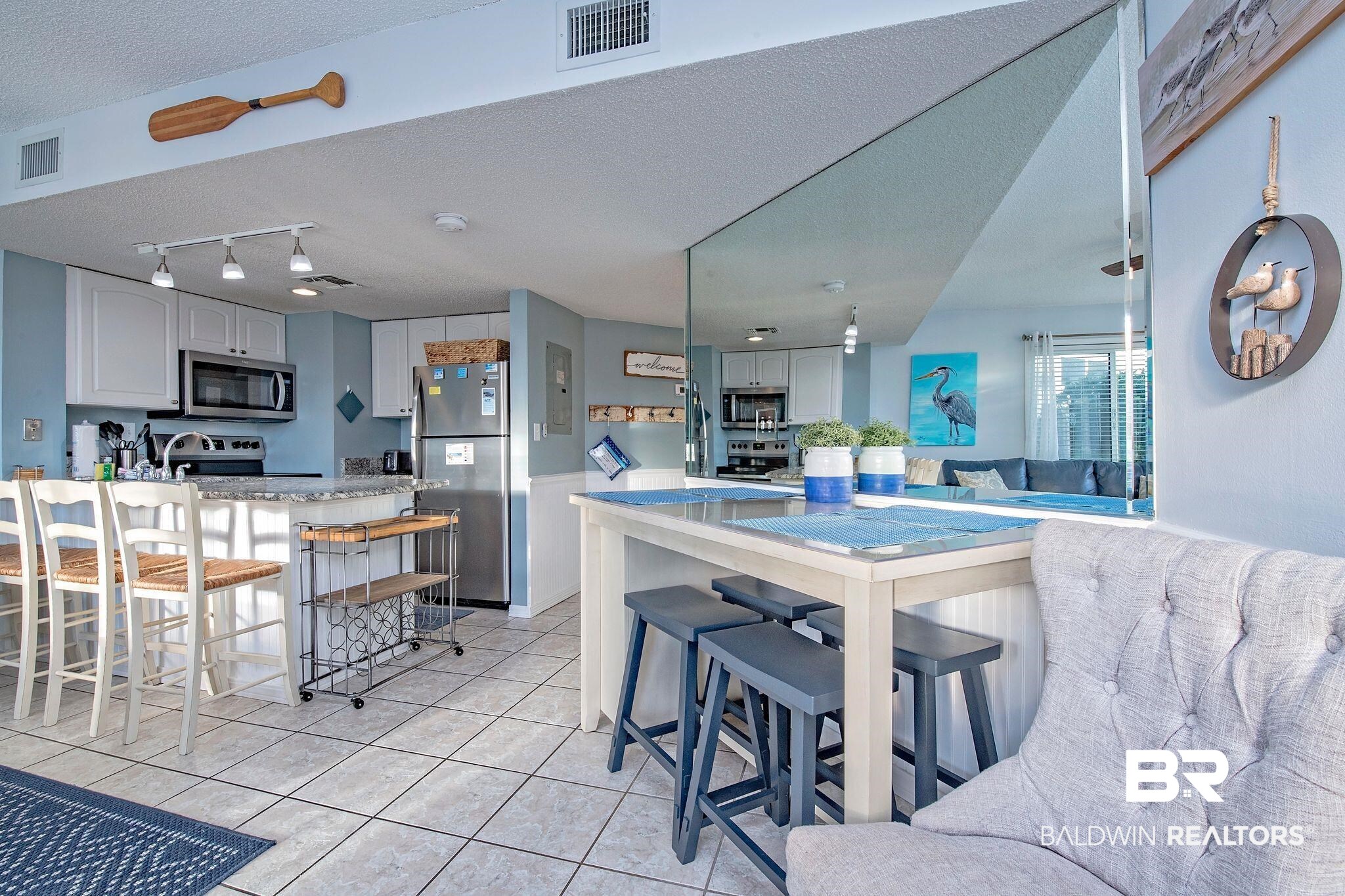 497 Plantation Road, Unit 1156 Gulf Shores, AL 36542 - Photo 10 of 28 Kitchen with stainless steel appliances, a kitchen breakfast bar, kitchen peninsula, and light tile patterned floors