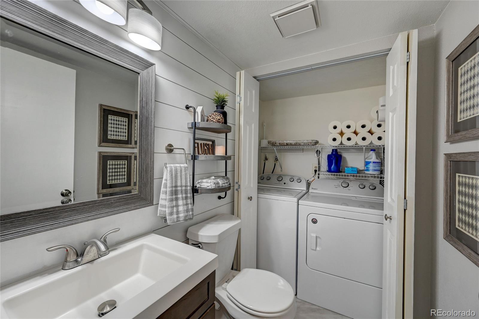 1225 South Oneida Street, Unit 219 Denver, CO 80224 - Photo 13 of 25 a bathroom with a sink vanity mirror and toilet