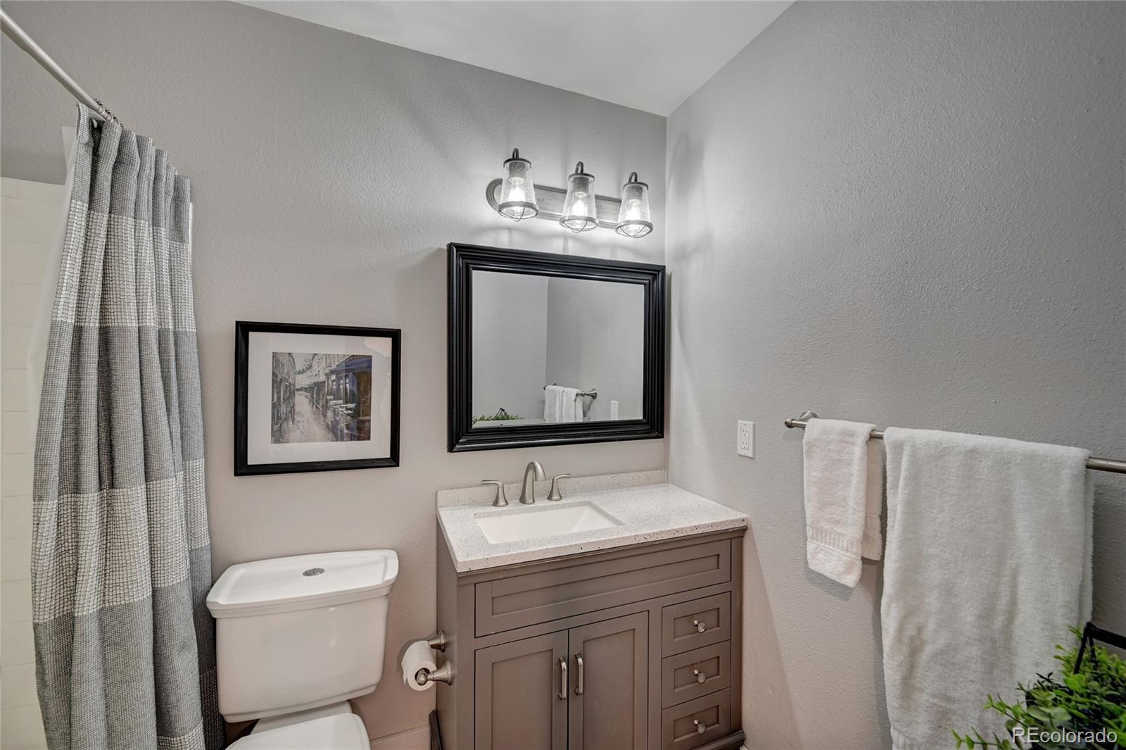 1225 South Oneida Street, Unit 219 Denver, CO 80224 - Photo 17 of 25 a bathroom with a toilet sink and mirror