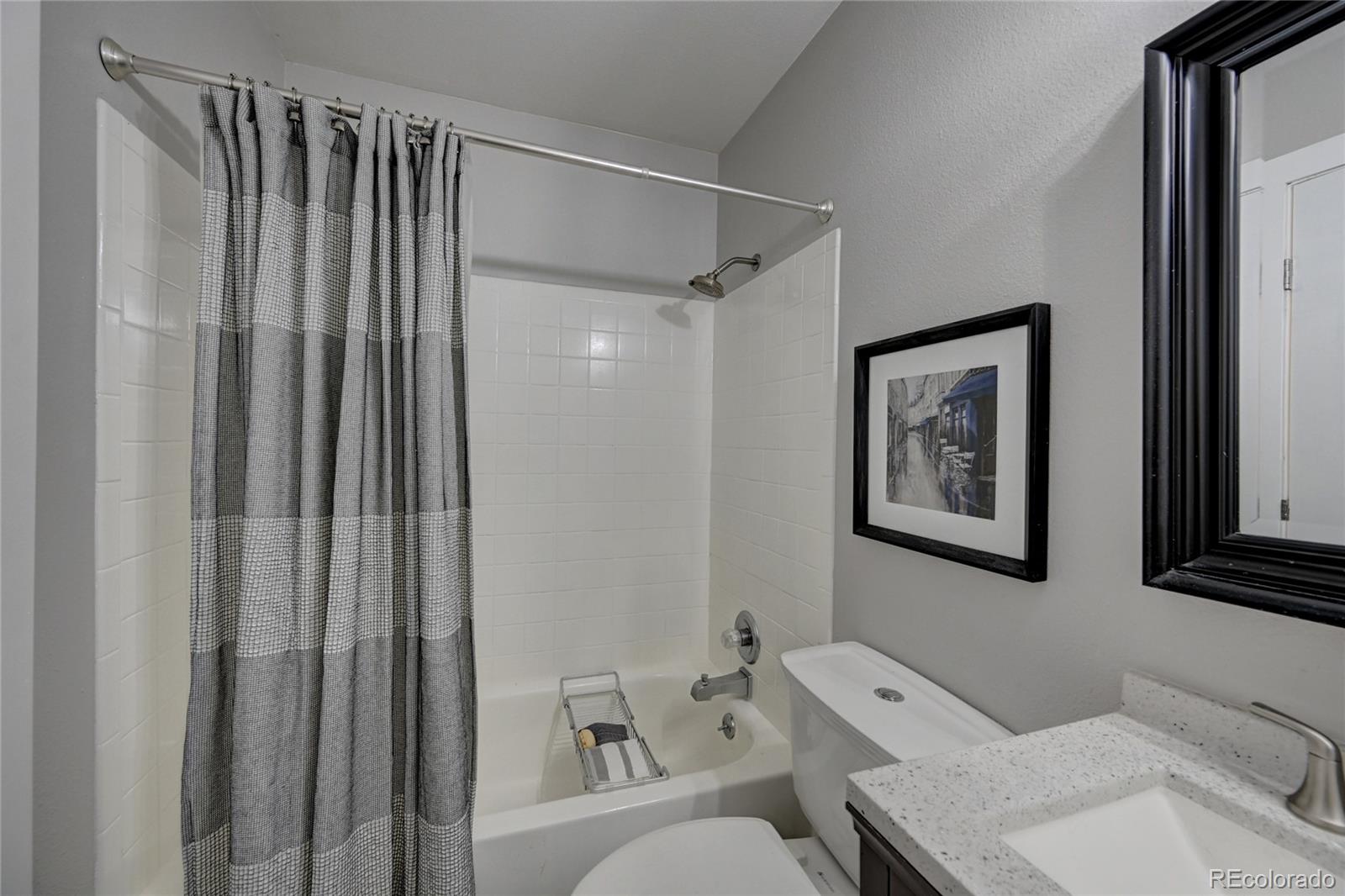 1225 South Oneida Street, Unit 219 Denver, CO 80224 - Photo 18 of 25 a bathroom with a toilet a sink and a shower