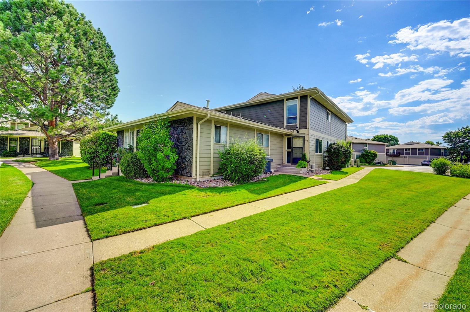 1225 South Oneida Street, Unit 219 Denver, CO 80224 - Photo 2 of 25 a front view of a house with a yard
