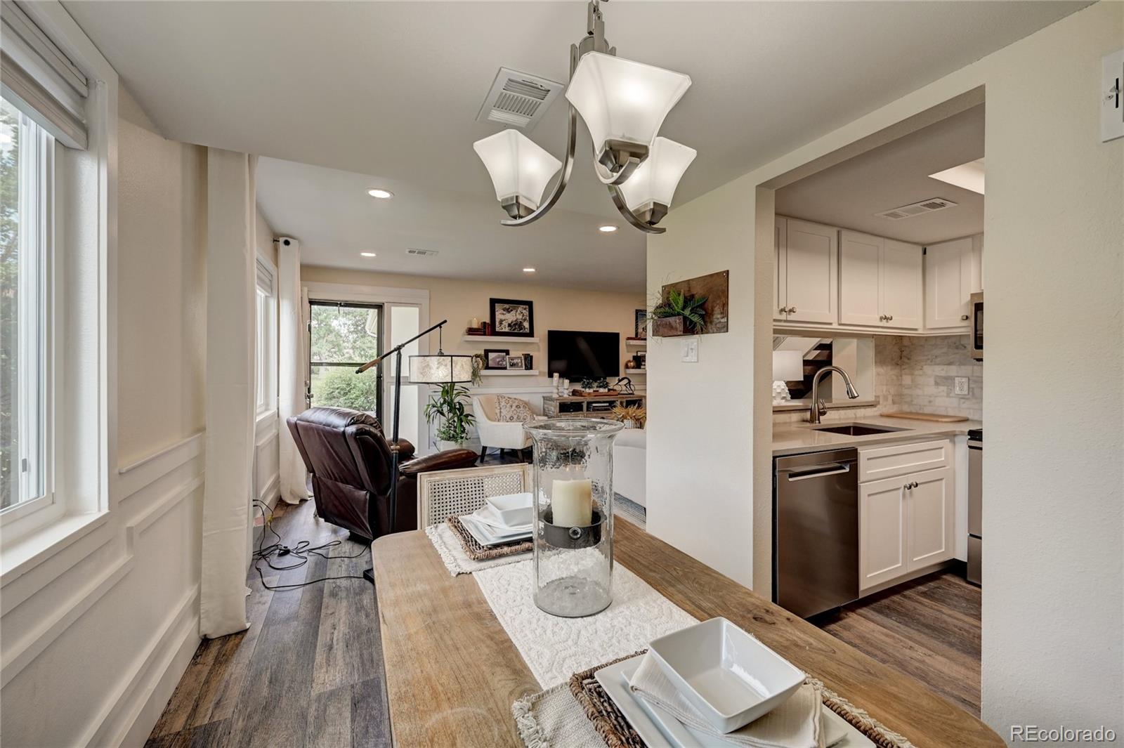 1225 South Oneida Street, Unit 219 Denver, CO 80224 - Photo 8 of 25 a kitchen with stainless steel appliances granite countertop a stove top oven a refrigerator a sink dishwasher and white cabinets with wooden floor