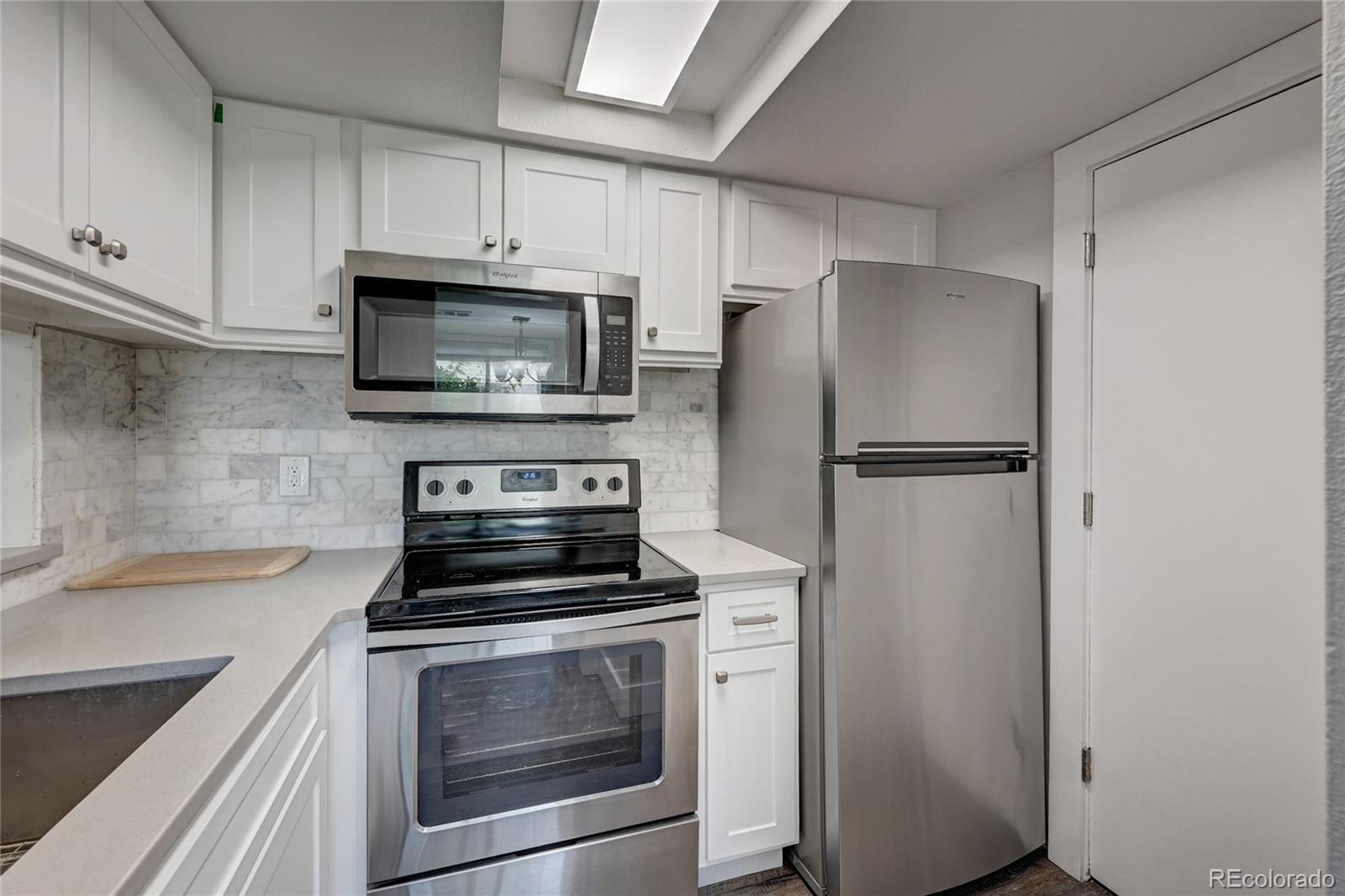 1225 South Oneida Street, Unit 219 Denver, CO 80224 - Photo 10 of 25 a kitchen with cabinets stainless steel appliances and a counter space