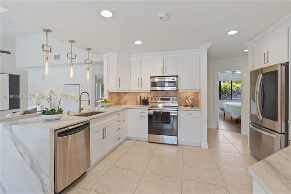 a kitchen with stainless steel appliances granite countertop a refrigerator sink and stove