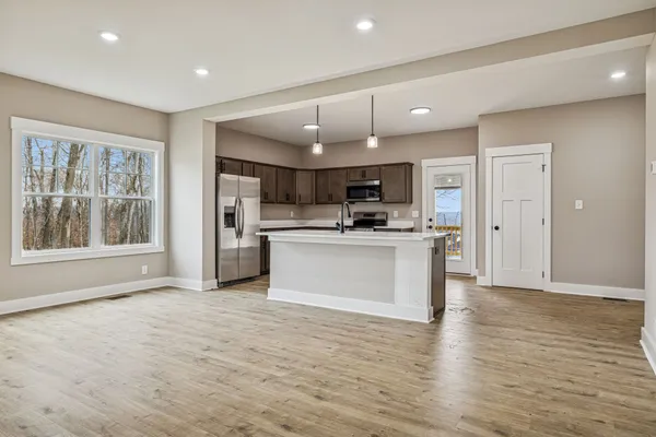 a large kitchen with cabinets wooden floor and stainless steel appliances