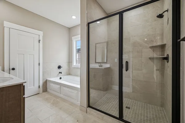 a bathroom with a tub a sink and a large mirror